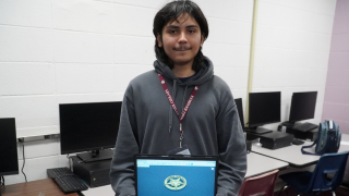  Jimmy holding a laptop displaying his design